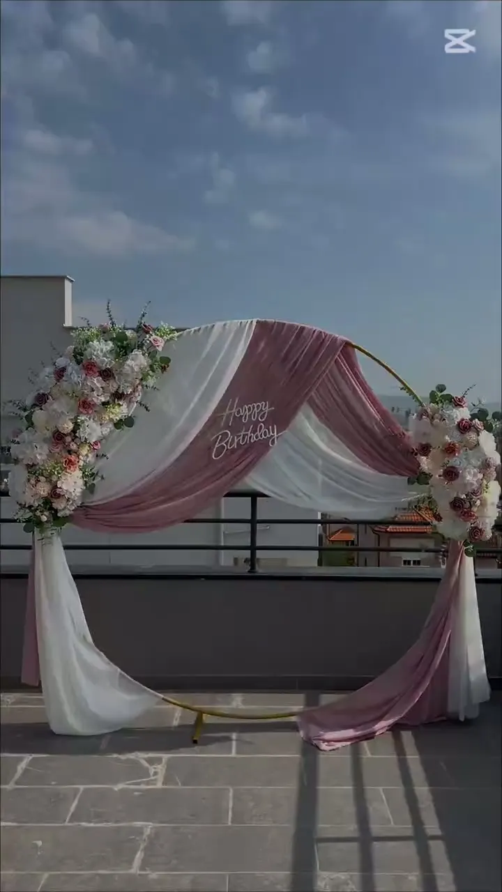Luk sa dusty rose draperijom i dva cvetna aranžmana na krovnoj terasi