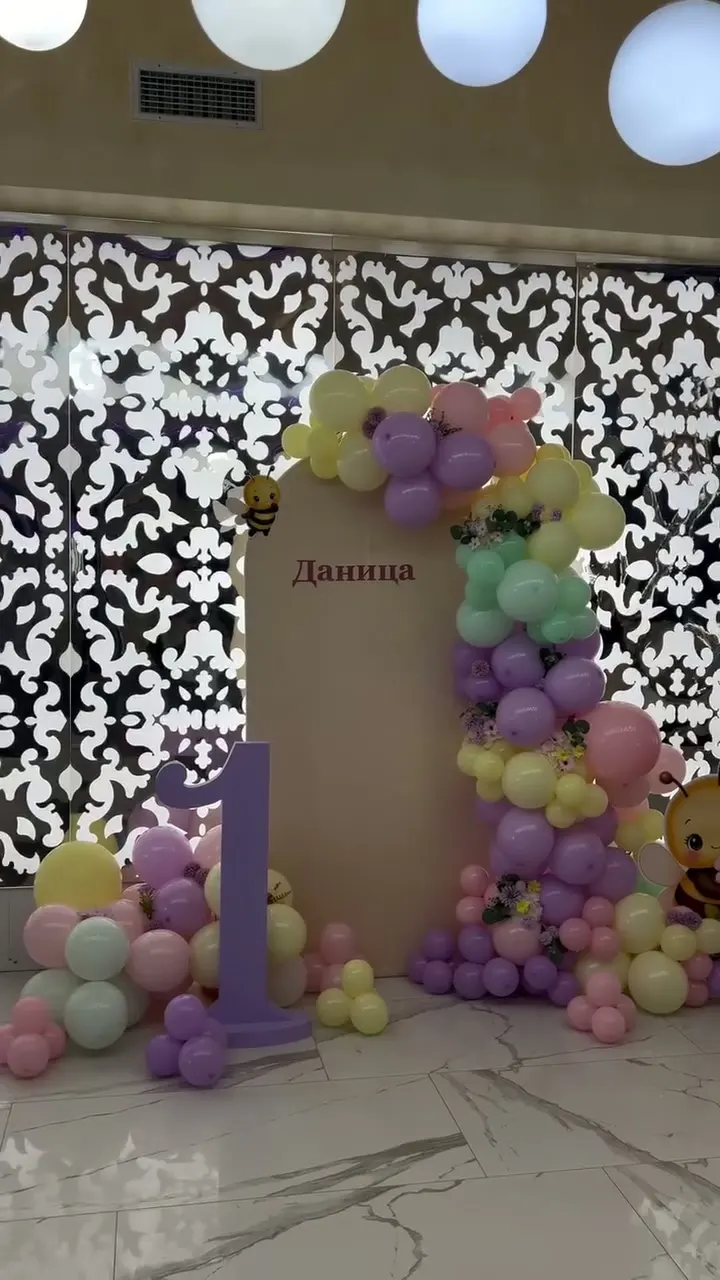 Pastelna dekoracija prvog rođendana sa pčelicom, balon girlandom i brojem 1