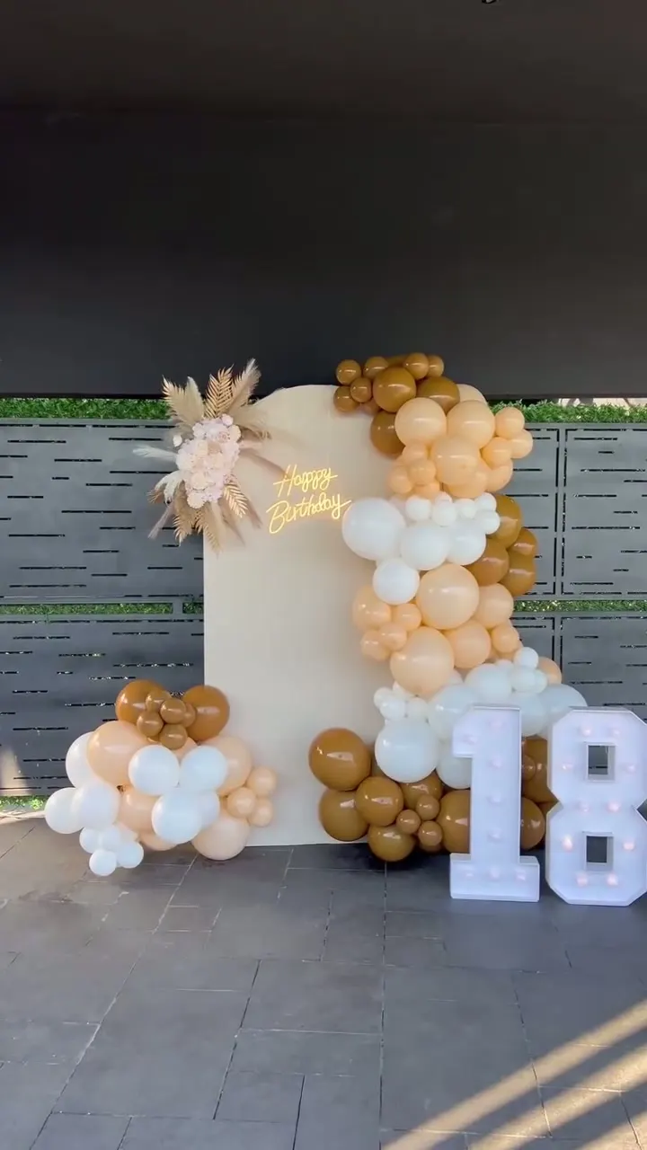Dekoracija 18. rođendana — luk sa balon girlandom, cvetnim aranžmanom i svetlećim brojevima